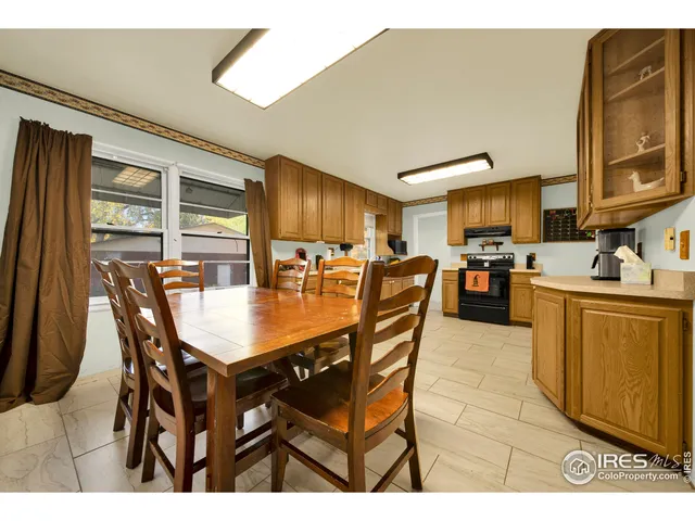 a dining hall with stainless steel appliances kitchen island granite countertop a dining table chairs and granite counter tops