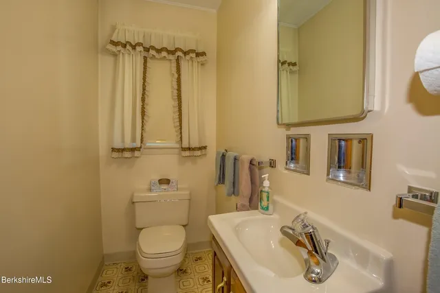 a bathroom with a toilet sink vanity and mirror
