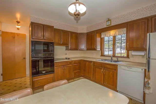 a kitchen with kitchen island granite countertop a stove cabinets and refrigerator