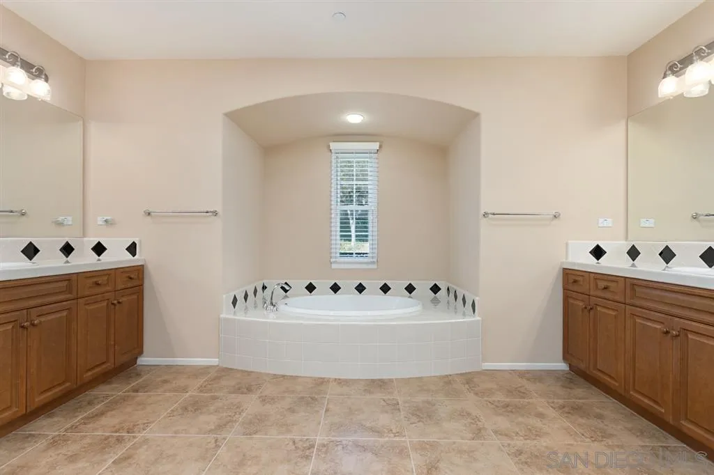 1757 Monte Mar Road Vista, CA 92084 - Photo 16 of 25 a spacious bathroom with a bathtub sink and mirror