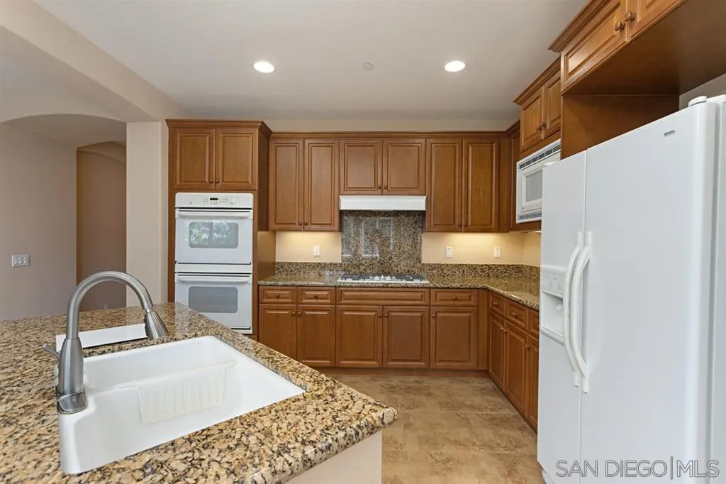 1757 Monte Mar Road Vista, CA 92084 - Photo 4 of 25 a kitchen with stainless steel appliances granite countertop a sink stove and refrigerator