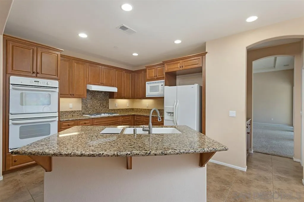 1757 Monte Mar Road Vista, CA 92084 - Photo 5 of 25 a kitchen with granite countertop a refrigerator and a sink