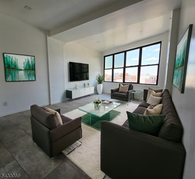 30 Howe Avenue, Unit 303 Passaic, NJ 07055 - Photo 1 of 11 a living room with furniture and a flat screen tv
