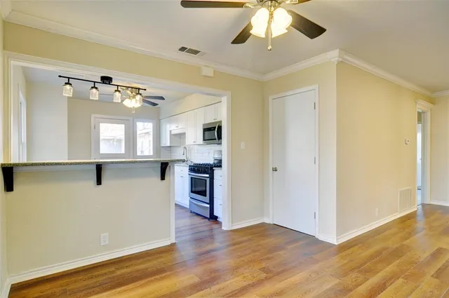 a view of a kitchen with wooden floor and a ceiling fan