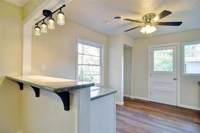 a room with a chandelier fan and windows