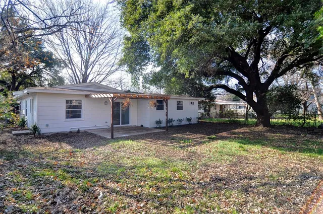 a view of a yard with a house and a tree