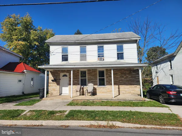 a front view of a house with a yard and potted plants