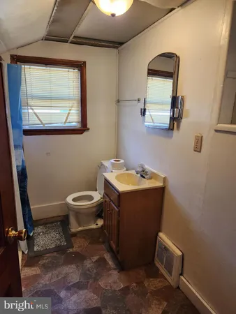 a bathroom with a toilet sink and mirror