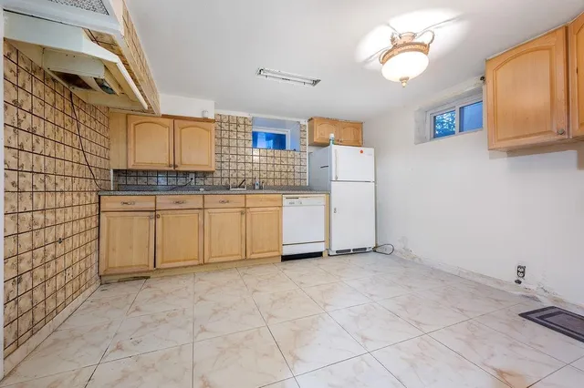 a kitchen with granite countertop a stove a sink and a refrigerator