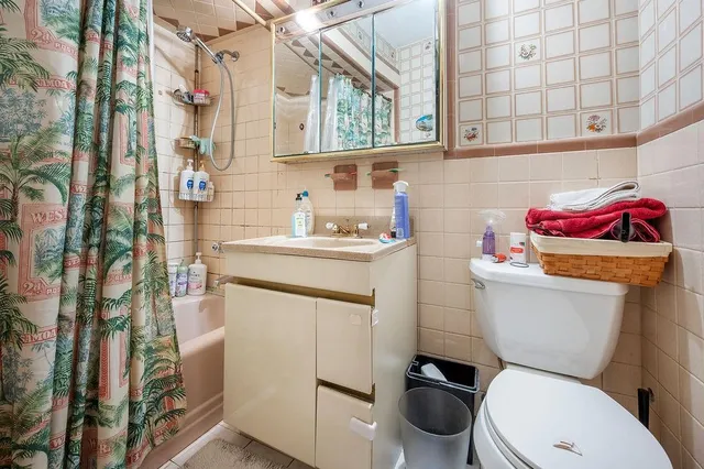 a bathroom with a toilet sink vanity and mirror