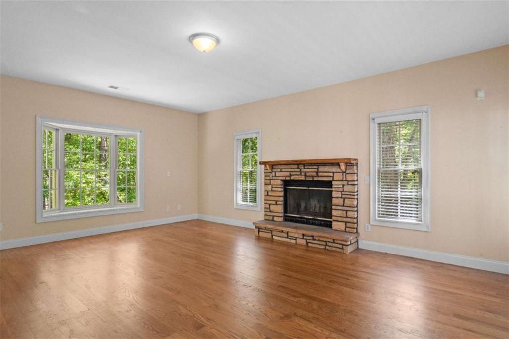 2058 Sewanee Court Villa Rica, GA 30180 - Photo 58 of 81 an empty room with windows a fireplace and wooden floor