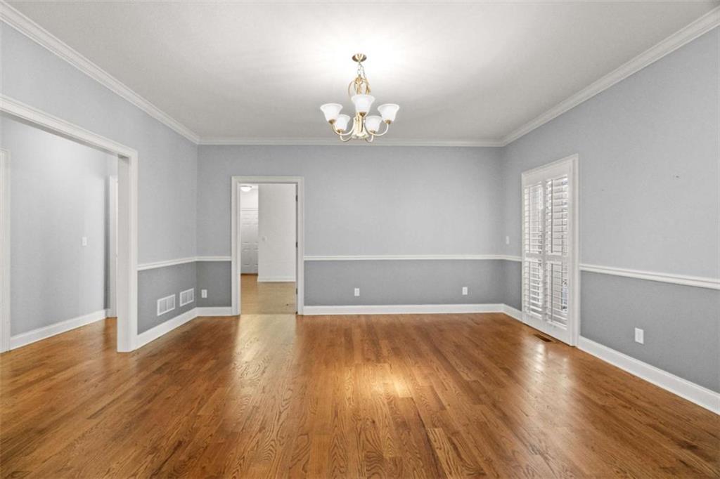 2058 Sewanee Court Villa Rica, GA 30180 - Photo 8 of 81 an empty room with wooden floor chandelier and windows