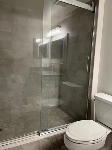 a white toilet next to a bathroom