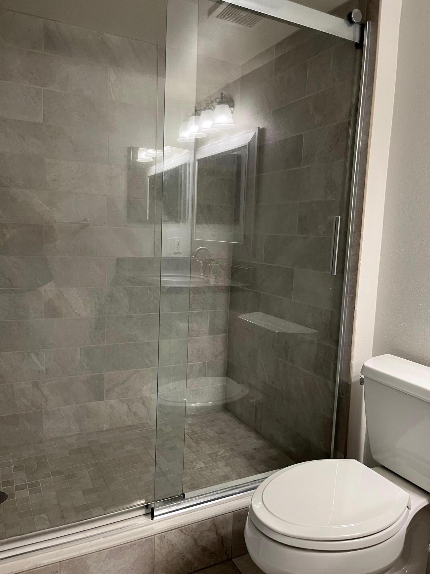 3769 Northwest Mediterranean Lane, Unit 2308 Jensen Beach, FL 34957 - Photo 12 of 16 a white toilet next to a bathroom