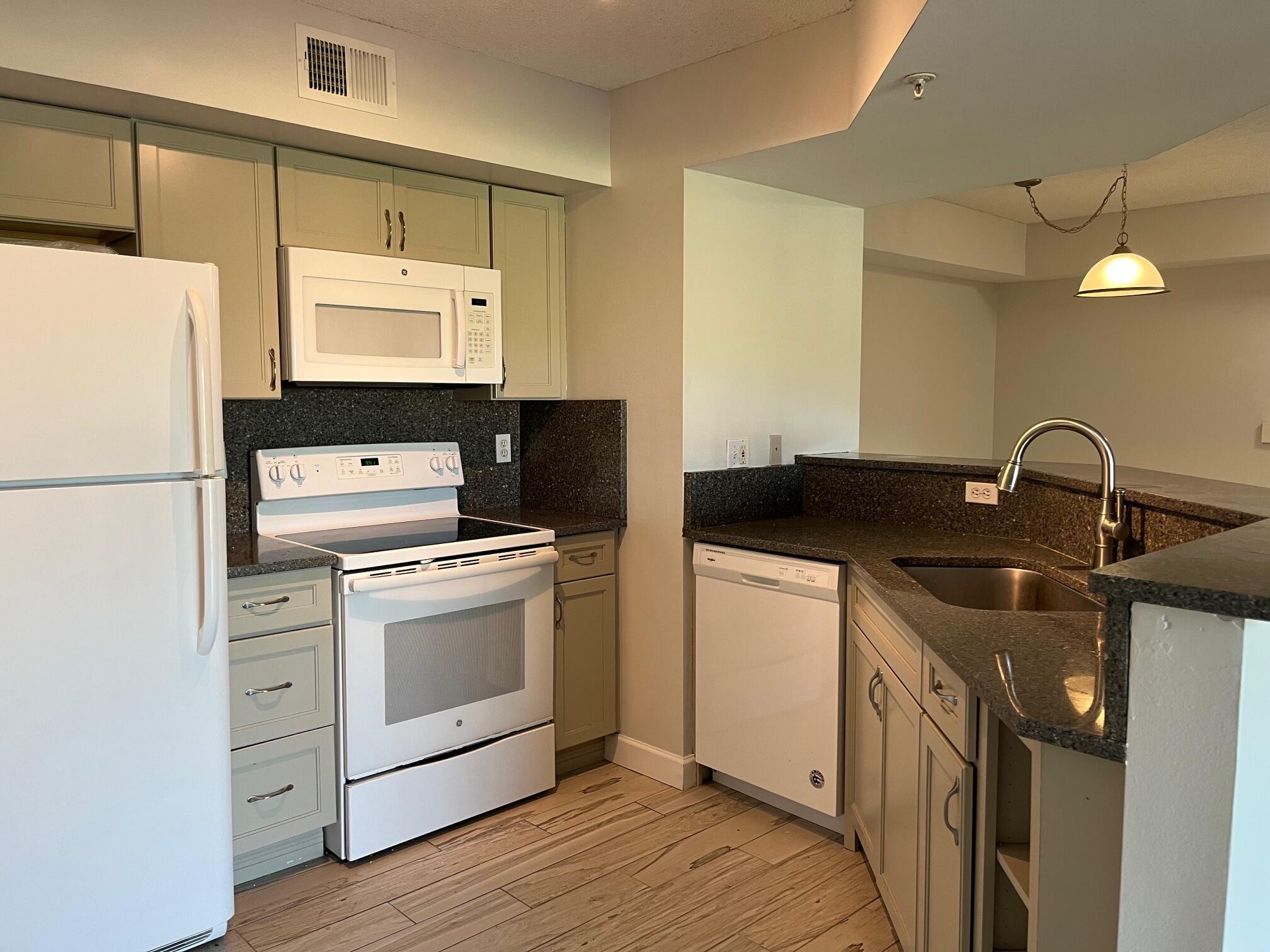 3769 Northwest Mediterranean Lane, Unit 2308 Jensen Beach, FL 34957 - Photo 3 of 16 a kitchen with a sink and a refrigerator