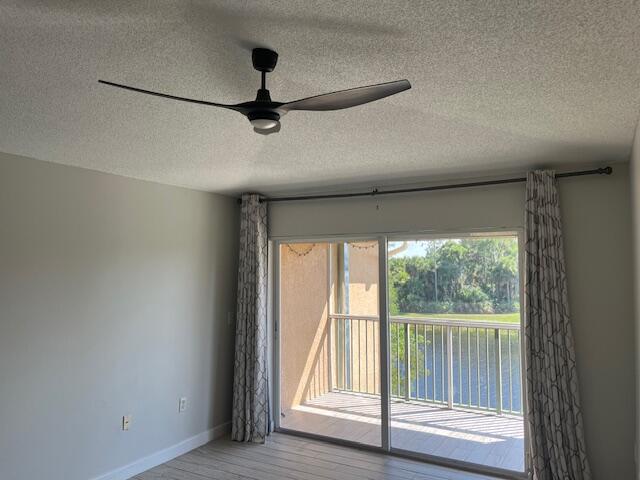 3769 Northwest Mediterranean Lane, Unit 2308 Jensen Beach, FL 34957 - Photo 6 of 16 a view of empty room with wooden floor and fan