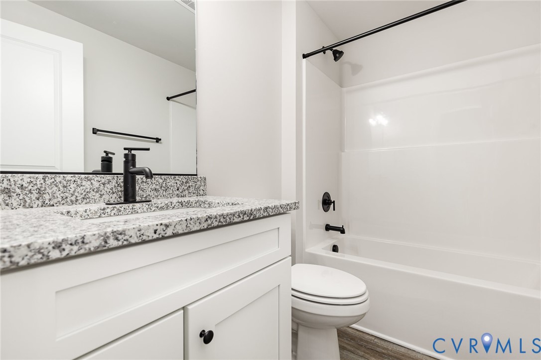 502 Smith Drive Ruther Glen, VA 22546 - Photo 27 of 34 a bathroom with a granite countertop sink a toilet and shower