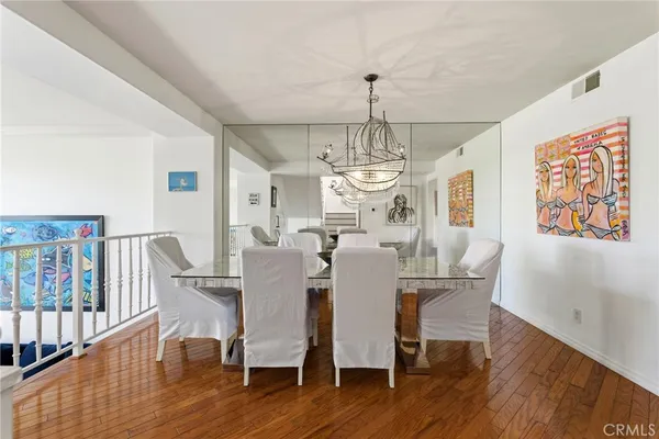 a view of a dining room with furniture a chandelier and wooden floor