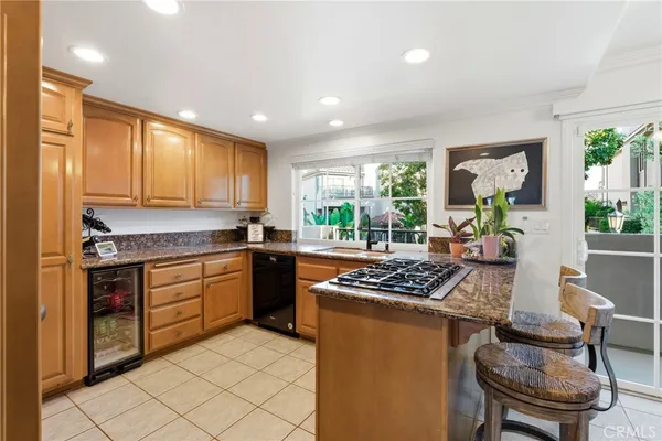 a kitchen with granite countertop a stove a sink dishwasher and white cabinets with wooden floor