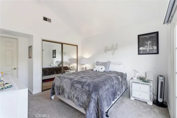 a bedroom with a bed a lamp and large closet