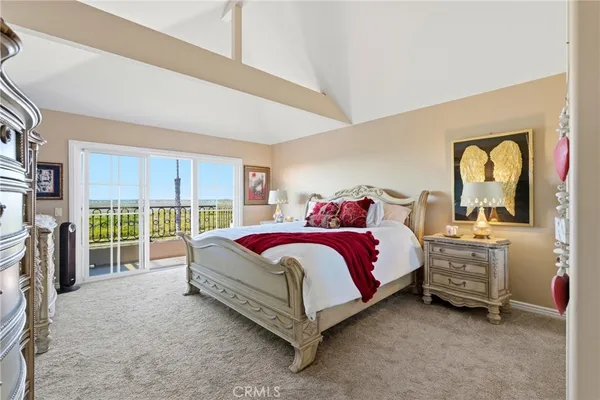 a spacious bedroom with a bed and a dresser next to a window