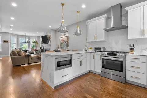 a kitchen with stainless steel appliances granite countertop a stove a sink and a refrigerator