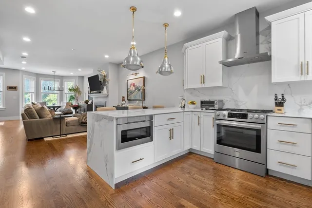 a kitchen with stainless steel appliances granite countertop a stove a sink and a refrigerator