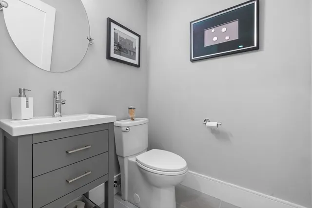 a bathroom with a toilet a sink and mirror