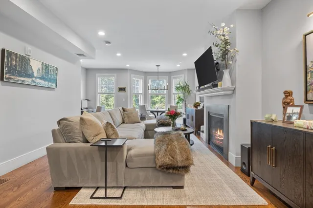 a living room with furniture a fireplace and a flat screen tv
