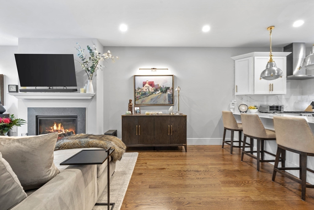 579 Baker Street, Unit 579 Boston, MA 02132 - Photo 4 of 30 a living room with furniture a flat screen tv and a fireplace