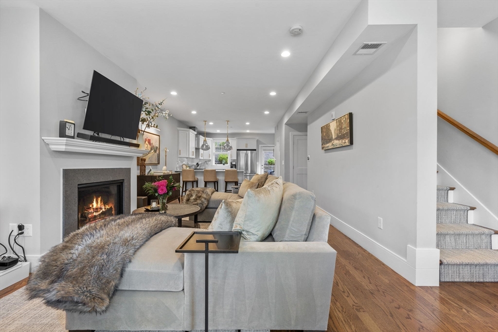 579 Baker Street, Unit 579 Boston, MA 02132 - Photo 7 of 30 a living room with furniture a flat screen tv and a fireplace