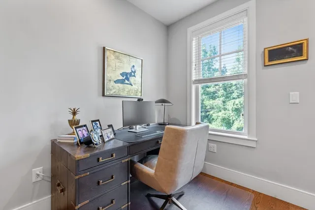 a view of a workspace with furniture and a window