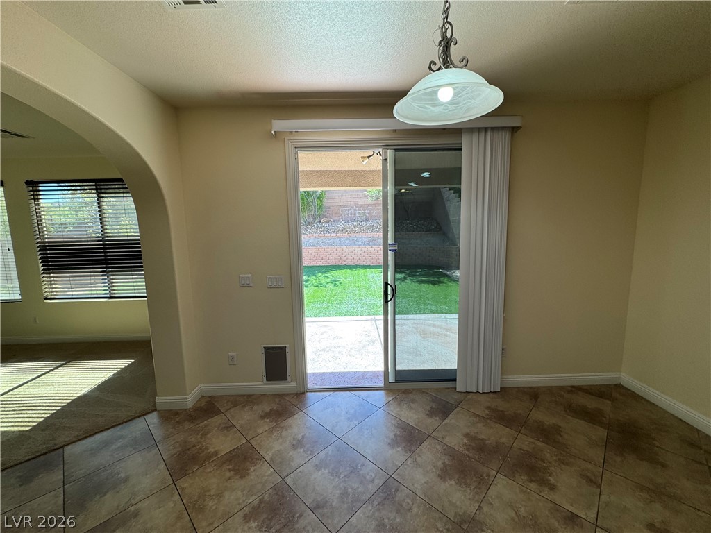 1333 Jamesbury Road Las Vegas, NV 89135 - Photo 20 of 43 Step out to a private yard from this functional dining space with durable tile flooring.