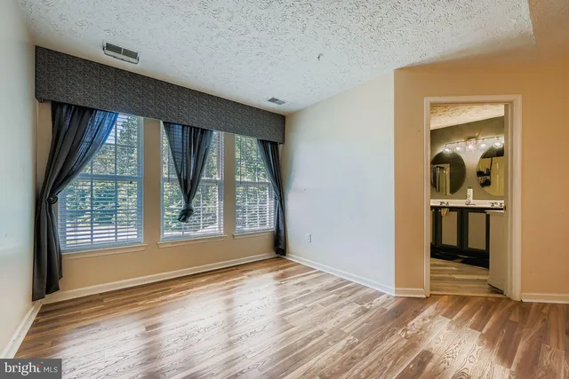 an empty room with wooden floor and a window
