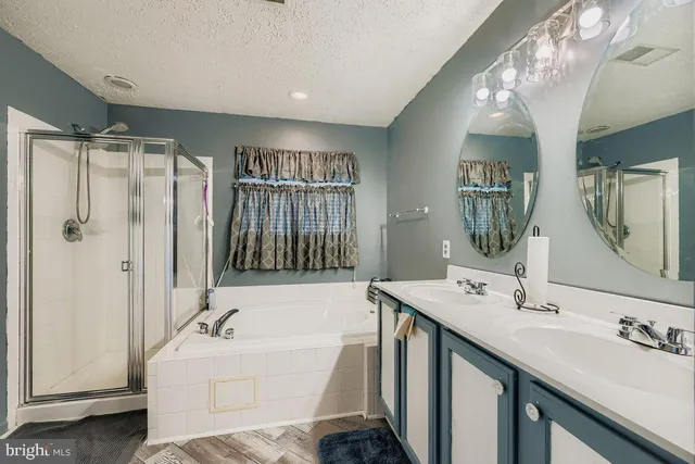 a bathroom with a tub sink and mirror