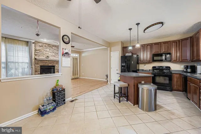 a kitchen with kitchen island granite countertop a stove top oven a sink a counter top space and cabinets
