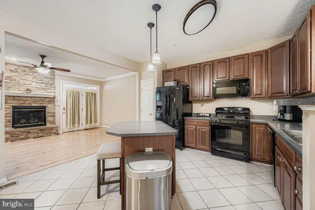 a kitchen with granite countertop a stove a sink and a refrigerator