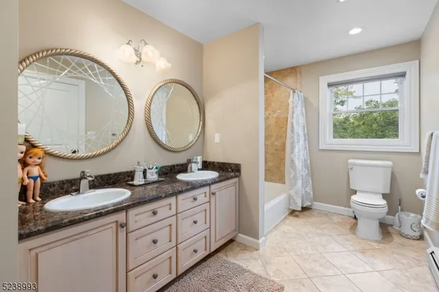 a bathroom with a granite countertop double vanity sink and a mirror