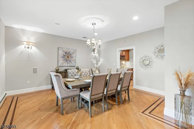 a dining room with furniture a chandelier and wooden floor