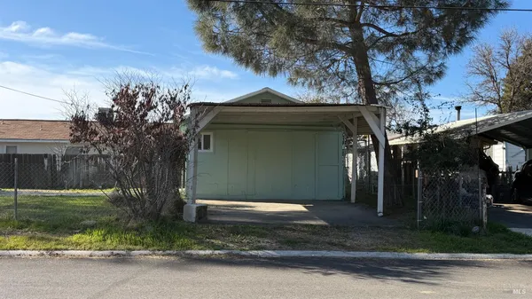 a front view of a house with a yard garage and trees
