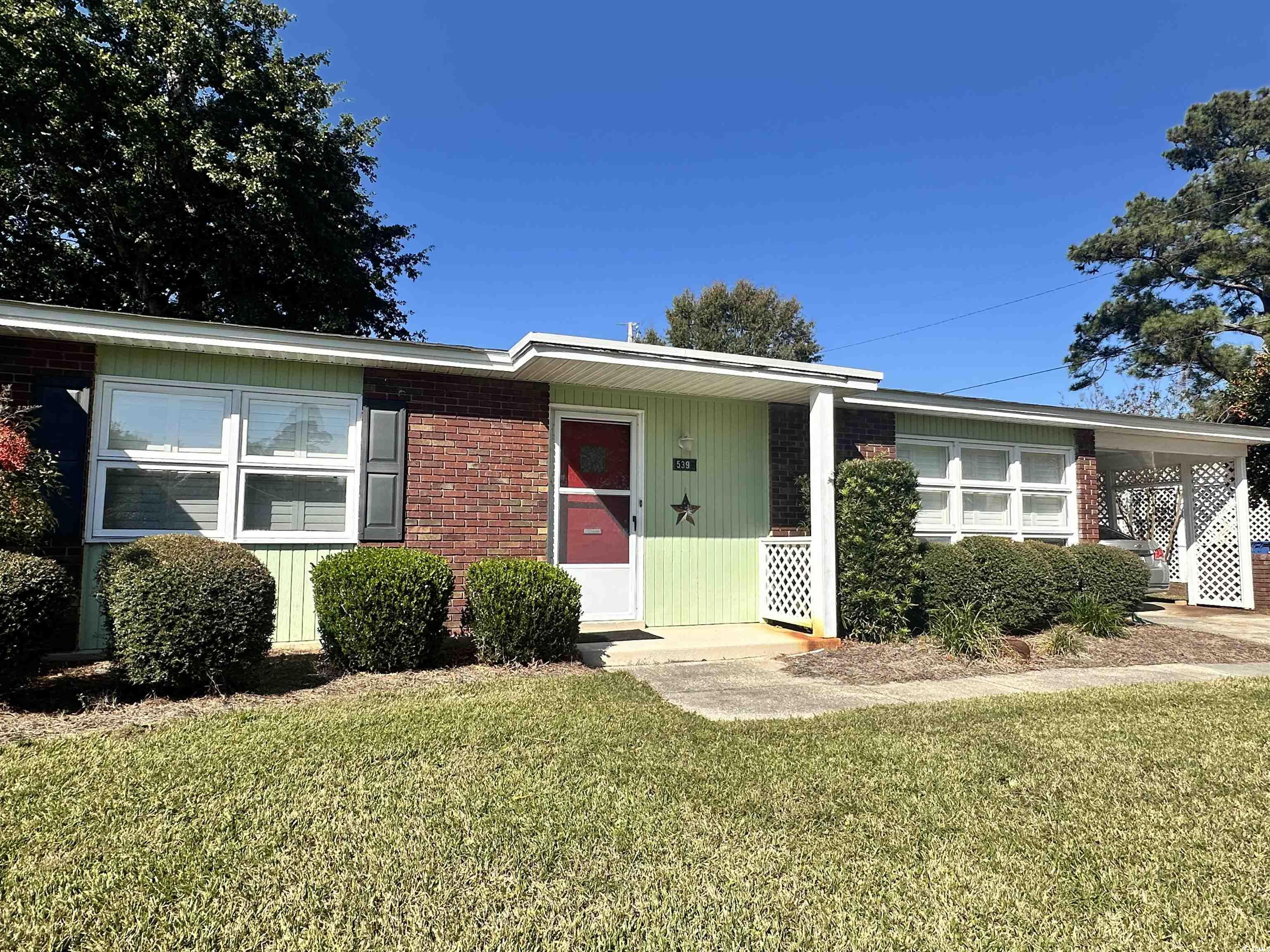 539 Redwood Avenue, Unit 539 Myrtle Beach, SC 29577 - Photo 1 of 23 Ranch-style home featuring a front yard, brick siding, and a carport