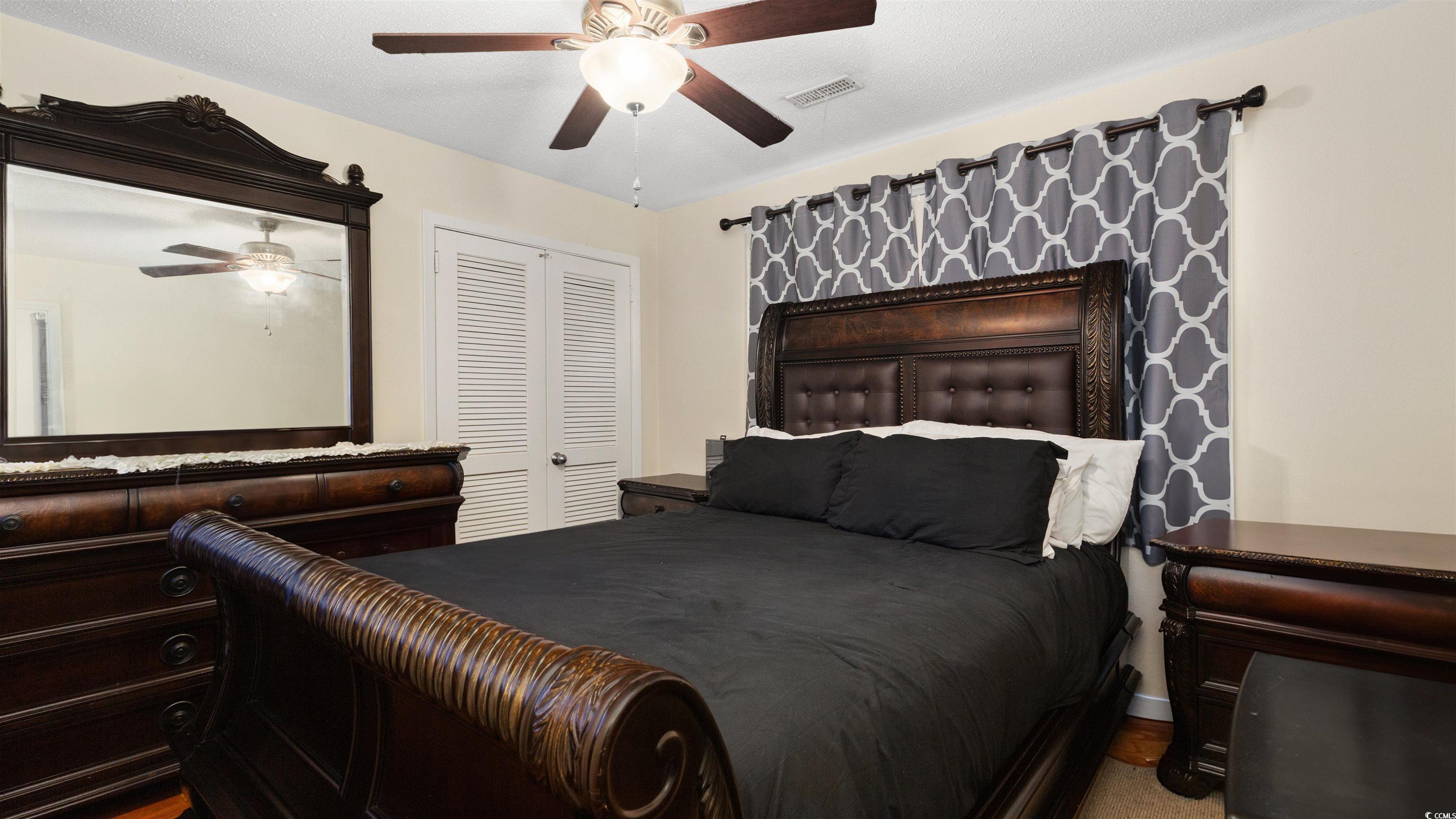 539 Redwood Avenue, Unit 539 Myrtle Beach, SC 29577 - Photo 14 of 23 Bedroom featuring a closet and ceiling fan and windows with curtain.