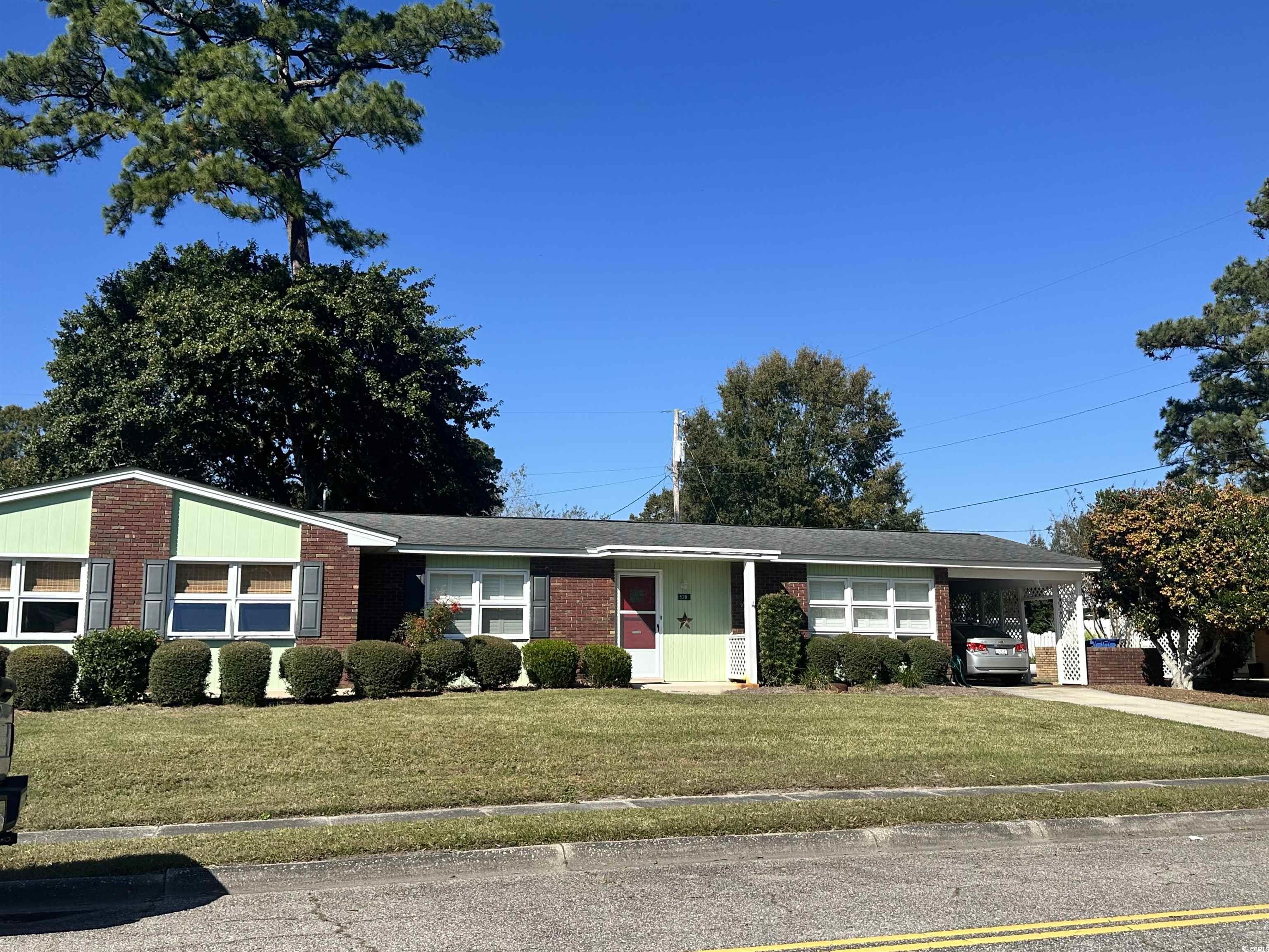 539 Redwood Avenue, Unit 539 Myrtle Beach, SC 29577 - Photo 2 of 23 Ranch-style home featuring a front lawn, a carport, brick siding, and driveway