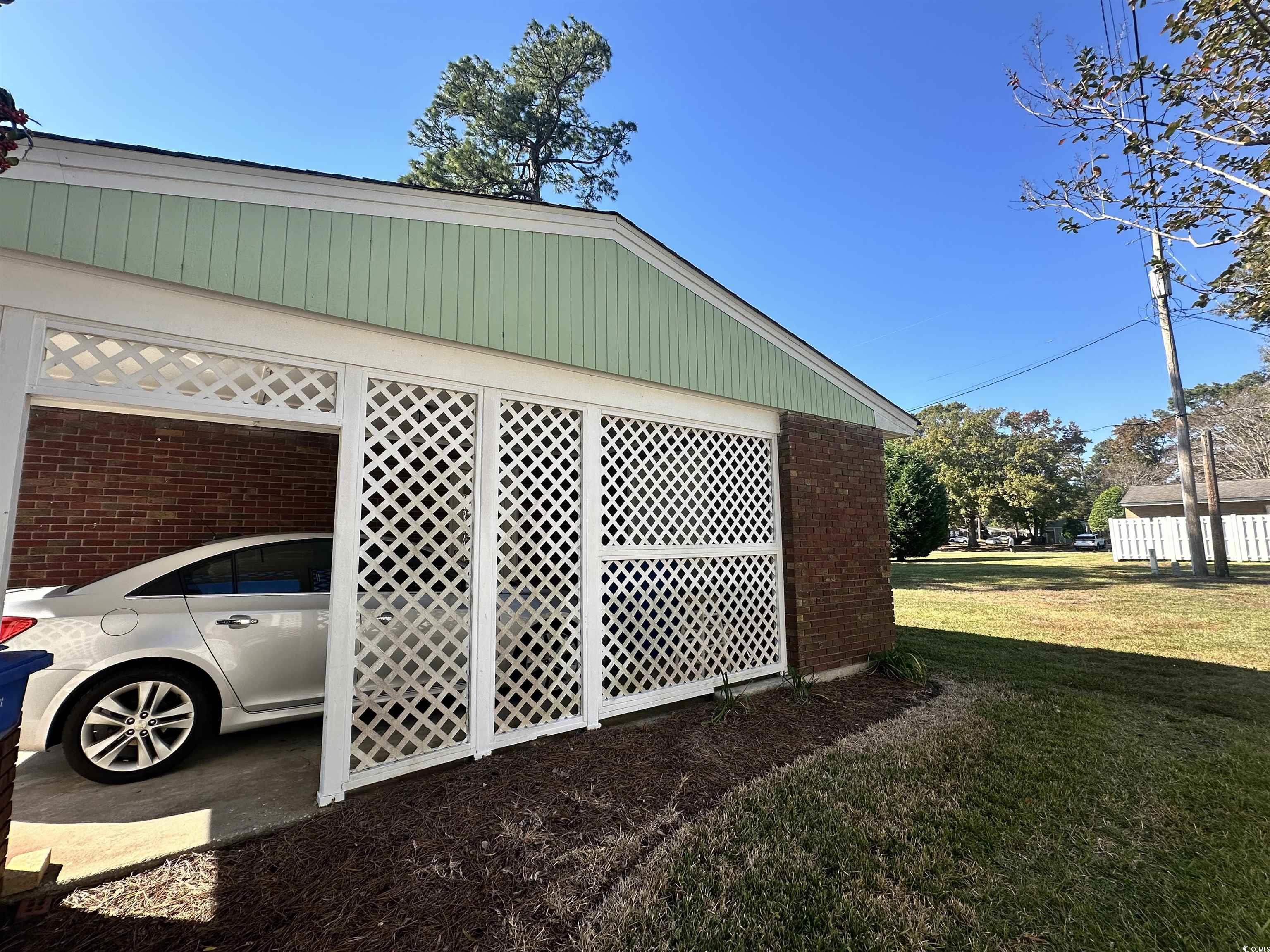 539 Redwood Avenue, Unit 539 Myrtle Beach, SC 29577 - Photo 28 of 42 View of carport and property exterior with brick siding and a yard