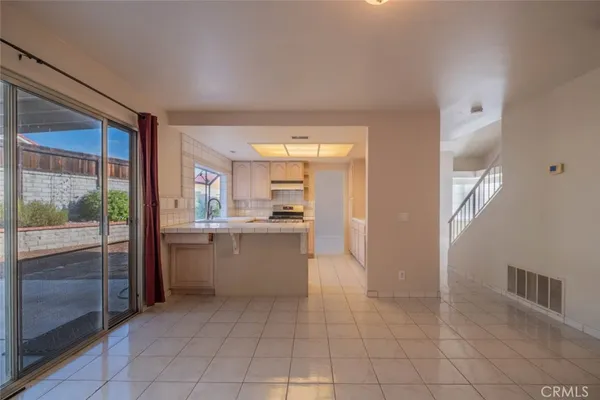 a room with a large window and kitchen view