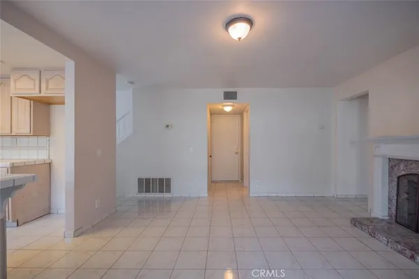 an empty room with fireplace and windows
