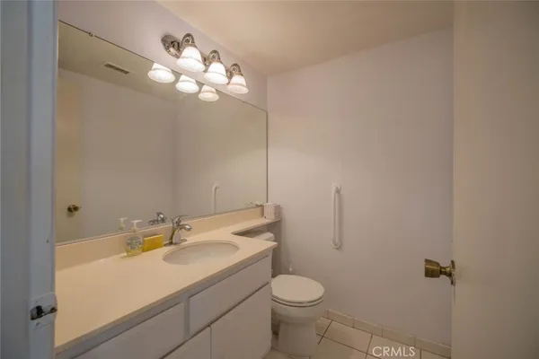 a bathroom with a sink vanity mirror and toilet