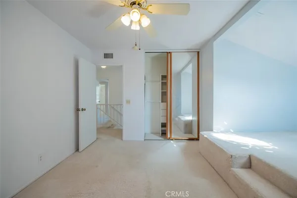 an empty room with fan and entrance