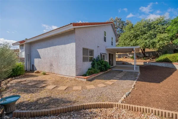 a backyard of a house with outdoor seating and trees