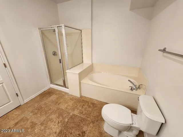 a bathroom with a toilet and a shower